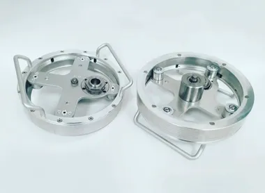Deux platines circulaires usinées en aluminium, équipées de roulements et de poignées